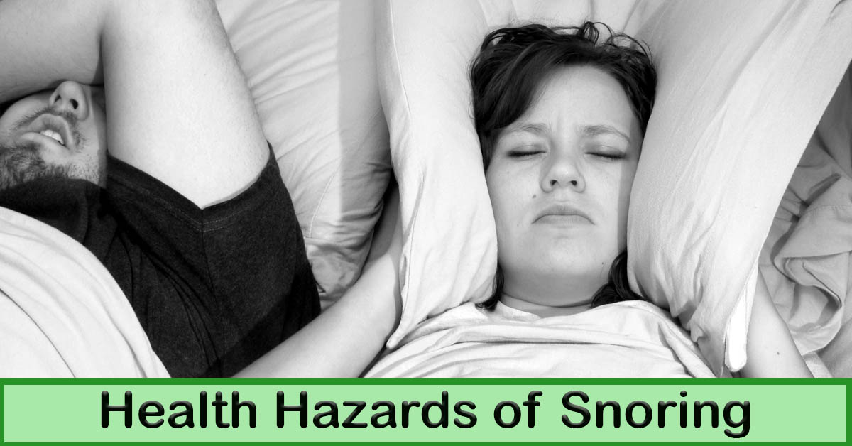 Health Hazards of Snoring. Picture of a caucasian male and female sleeping in bed, with the female having the pillow pulled up around her ears.